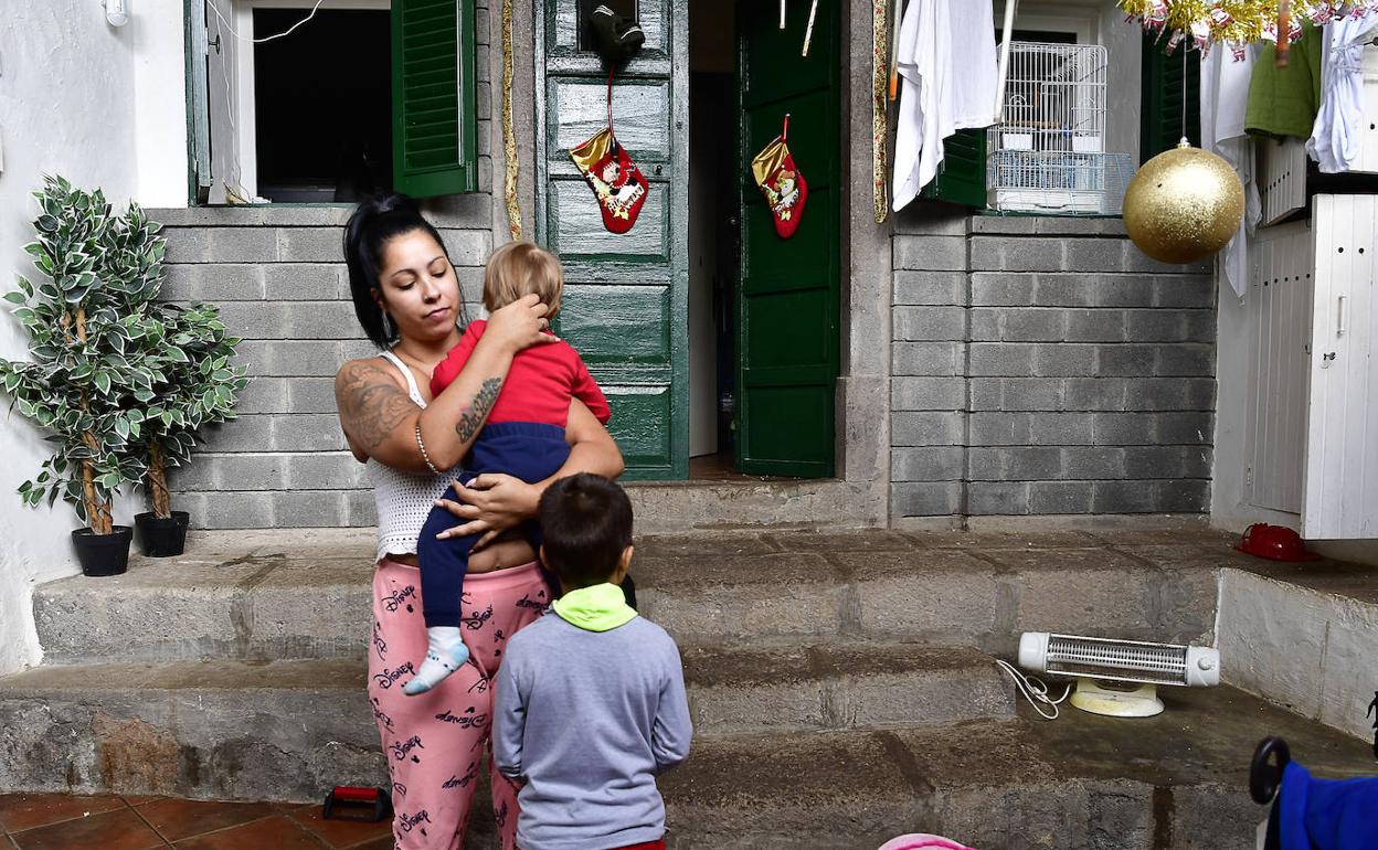 Irina, junto a sus dos niños, en el patio de la que todavía es su residencia.