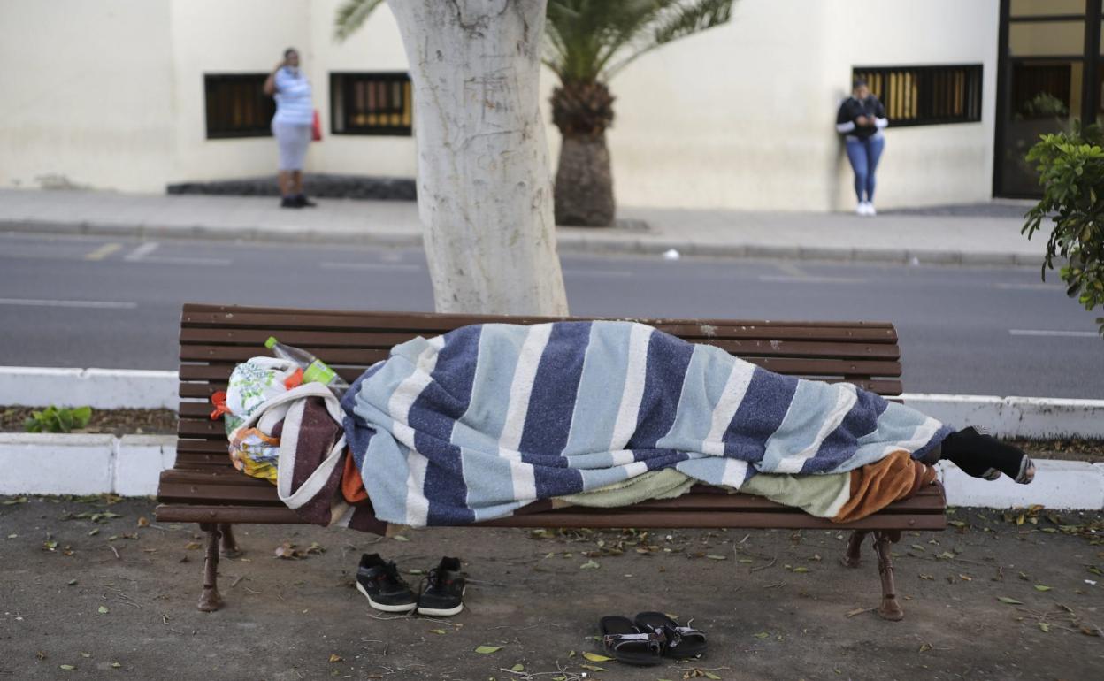Imagen de una persona sin hogar en un banco de Arrecife. 
