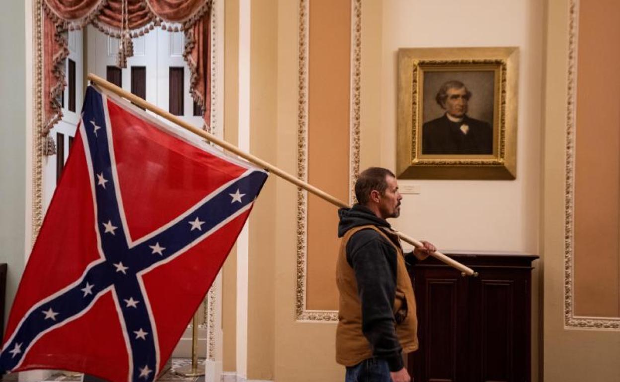 Un seguidor de Donald Trump en el Capitolio de EE UU con una bandera de los Estados Confederados 