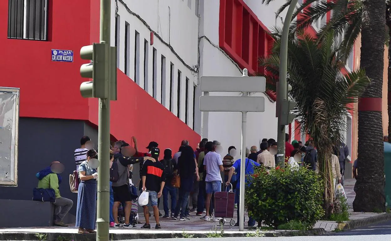 Cola de personas en Cáritas para recibir comida. 