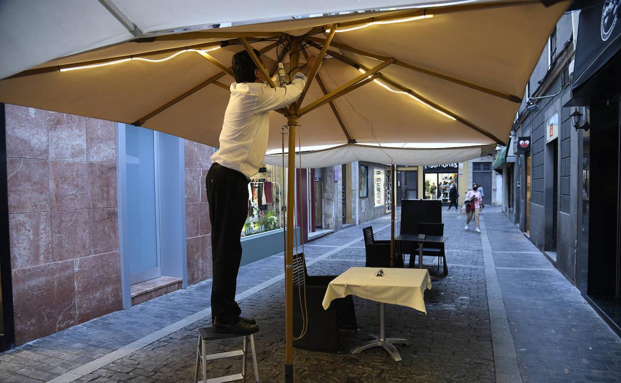 Un trabajador da los úlitmos retoques a su terraza en Triana. 