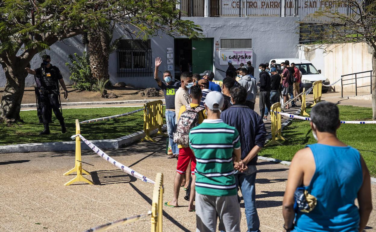 Inmigrantes haciendo cola en un comedor de Cáritas
