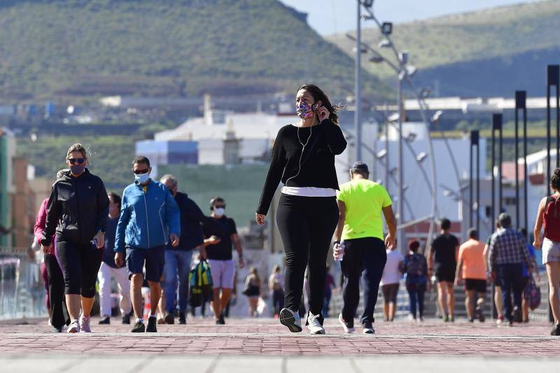 Gente con mascarillas paseando por la avenida de Las Canteras. 