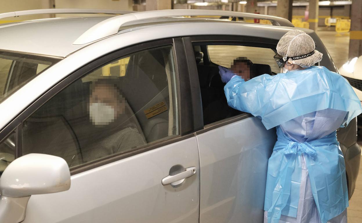 Una sanitaria hace un exudado en el puesto de toma de muestras para PCR del Gran Canaria Arena. 
