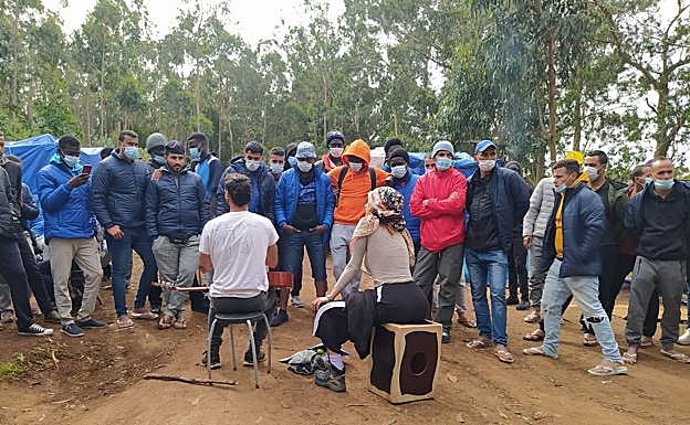 Un grupo de inmigrantes asiste ayer a un concierto improvisado de unos músicos franceses. 