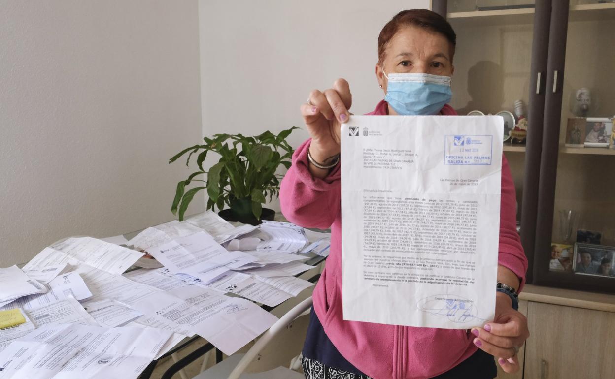 Teresa muestra el listado de recibos que adeuda y reconoce que otros se le acumulan por la falta de ingresos. 