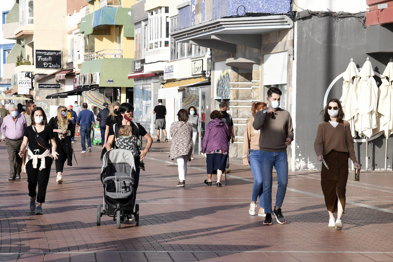 Imagen de archivo de personas con mascarilla en Las Canteras. 