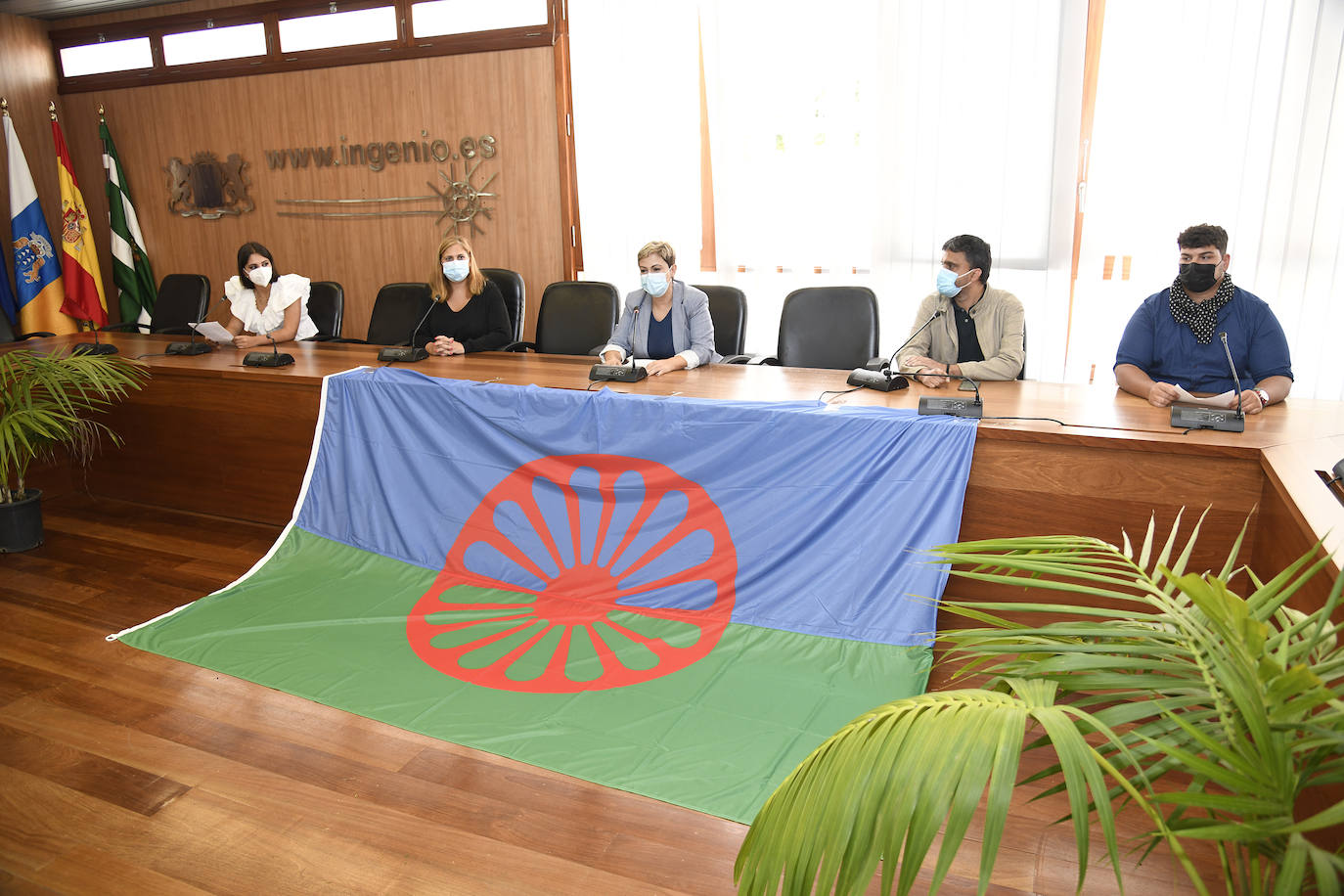 Acto oficial en el salón de plenos. En el centro, la bandera gitana.