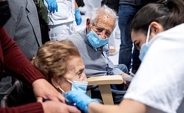 Dos personas vacunánose en una imagen de archivo. 