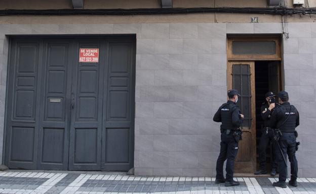 Imagen de agentes de la Policía Nacional custodiando la entrada al inmueble. 