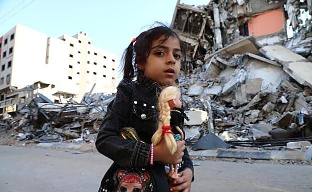 Un niña palestina pasa junto a un edificio destruido en un bombardeo. 