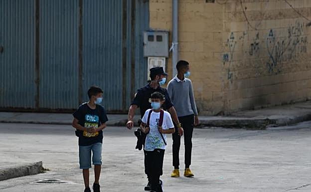 La Policía acompaña a menores a las naves acondicionadas anexas a la frontera del Tarajal. 