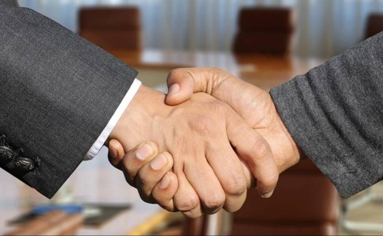 Dos ejecutivos se estrechan las manos para sellar un acuerdo. 