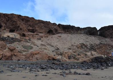 Imagen secundaria 1 - Foto superior, los arqueólogos cubren las estructuras con una malla geotextil y con piedras para su protección. Debajo, a la izquierda, vista del cantil en cuya falda están los vestigios excavados. A la derecha, escamador hecho de cuerno hallado en el enclave. 