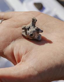 Imagen secundaria 2 - Vista desde un dron de las nuevas estructuras que se están excavando, una de las arqueólogas busca restos o fragmentos valiosos cerniendo tierra y foto ampliada de un idolillo hallado en esta campaña. 