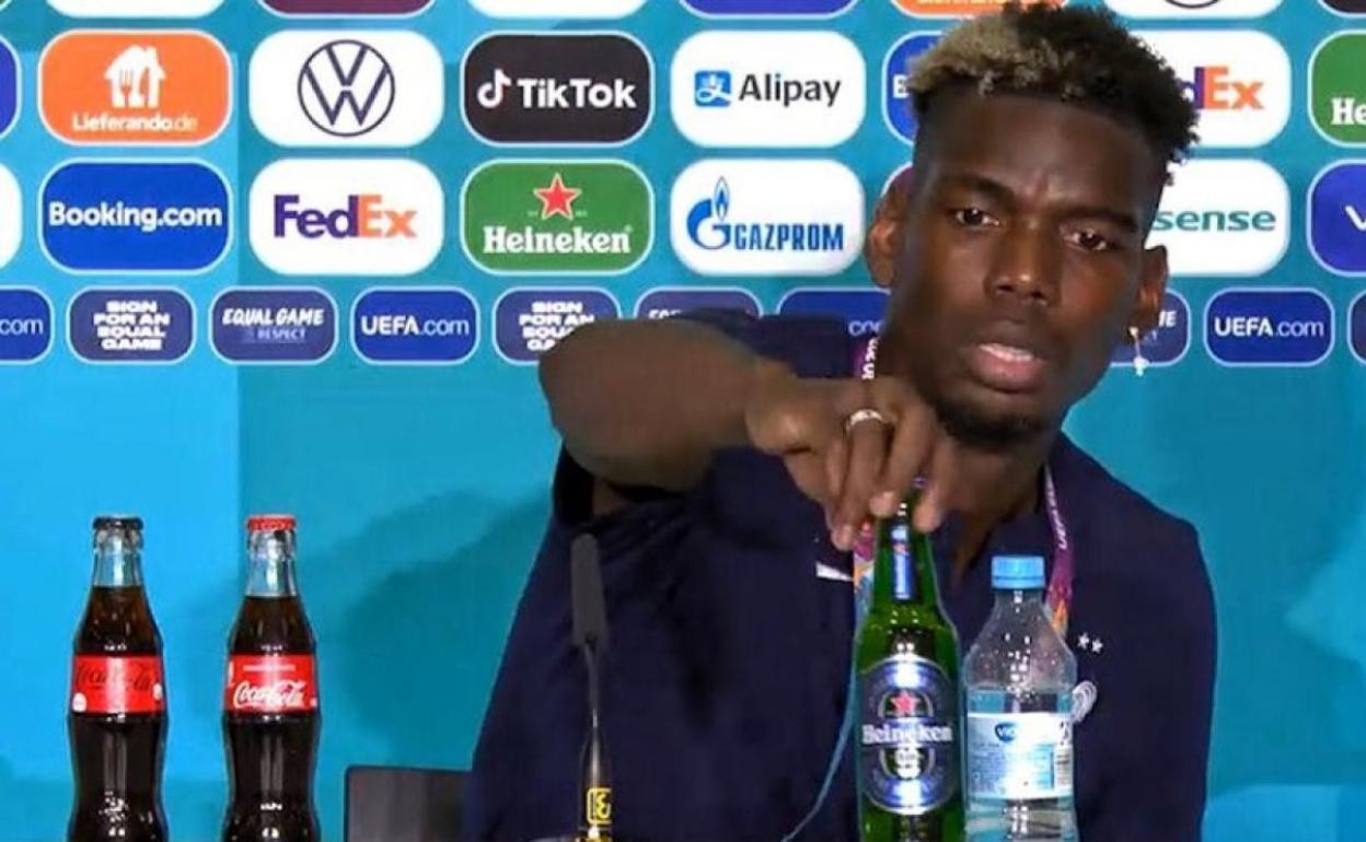 Pogba retira la botella de Heineken durante una rueda de prensa. 