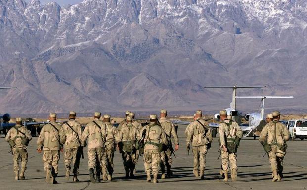 Los soldados estadounidenses se acercan a los aviones de las Naciones Unidas en la pista de la base aérea de Bargam en Bagram 