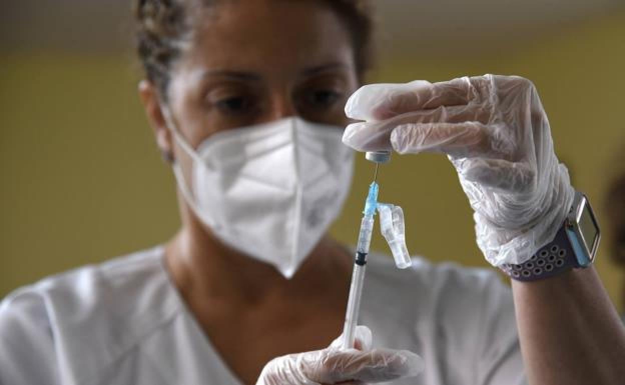 Una enfermera carga una dosis de vacuna en una jeringuilla. 