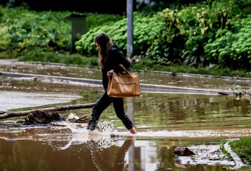 Una mujer camina por una calle inundada en la alemana ciudad de Hagen.