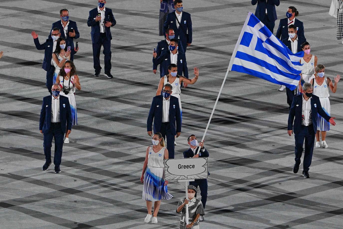 Los abanderados de Grecia, Anna Korakaki y Eleftherios Petrounias, encabezan la delegación helena a su entrada al Estadio Olímpico de Tokio. 