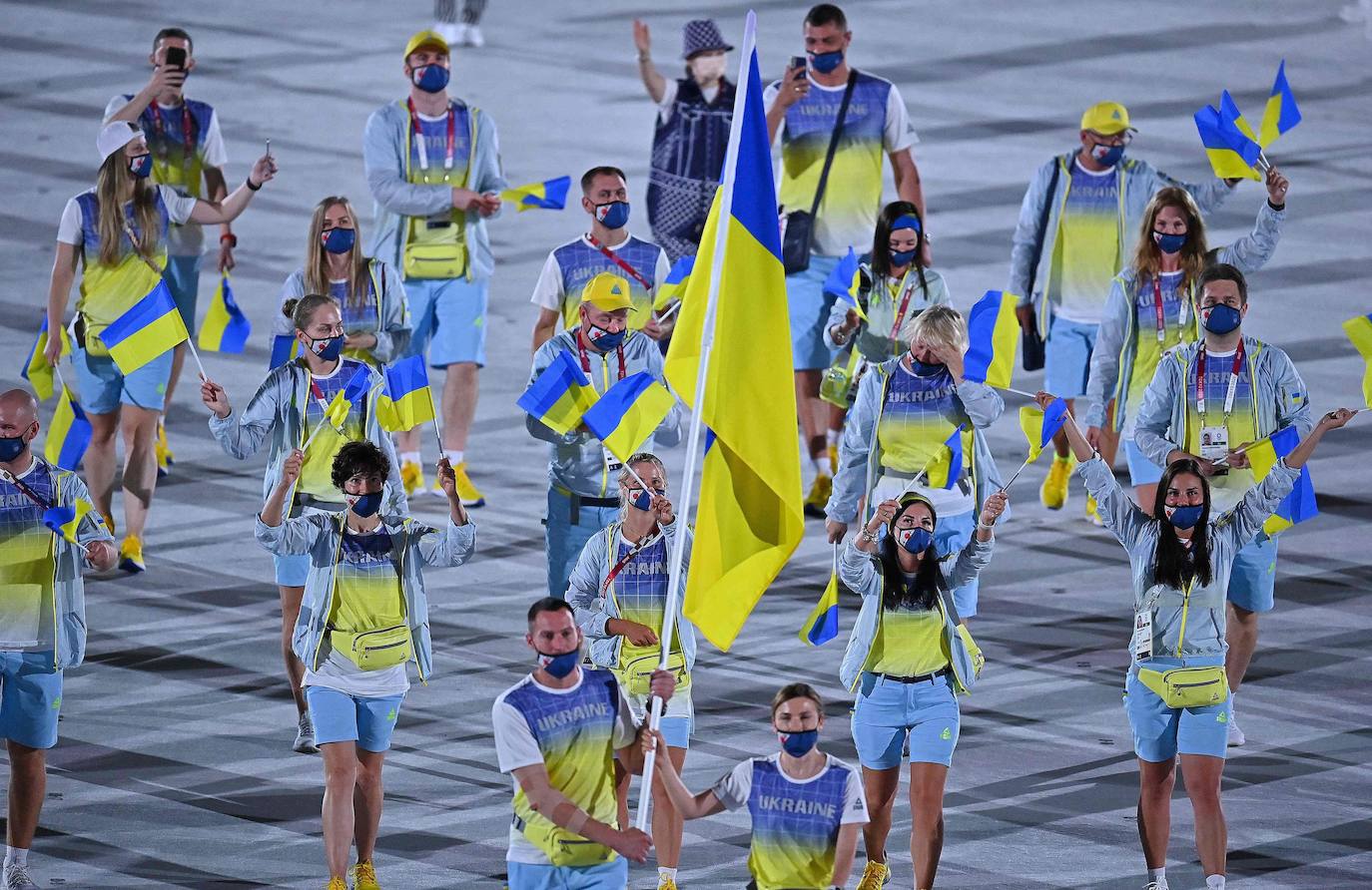 Olena Kostevych y Bogdan Nikishin, abenderados de Ucrania, encabezan su delegación durante el desfile en el Estadio Olímpico de Tokio. 
