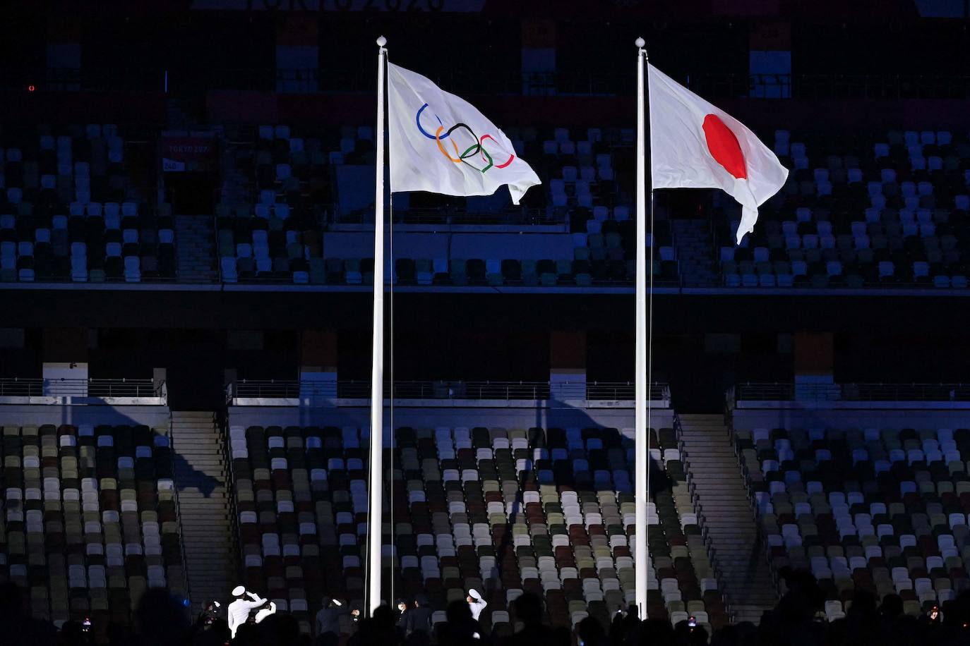 La bandera olímpica se iza junto a la bandera nacional japonesa durante la ceremonia de inauguración de los Juegos Olímpicos de Tokio 2020.