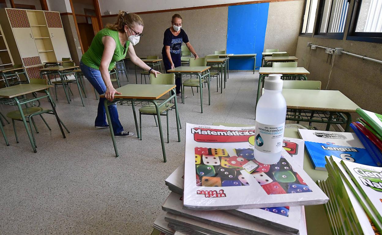Dos docentes preparan una clase con medidas anticovid