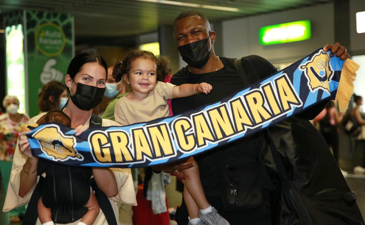 Ennis y su familia al completo posan con la bufanda de su nuevo equipo en la Liga Endesa tras aterrizar en la isla. 