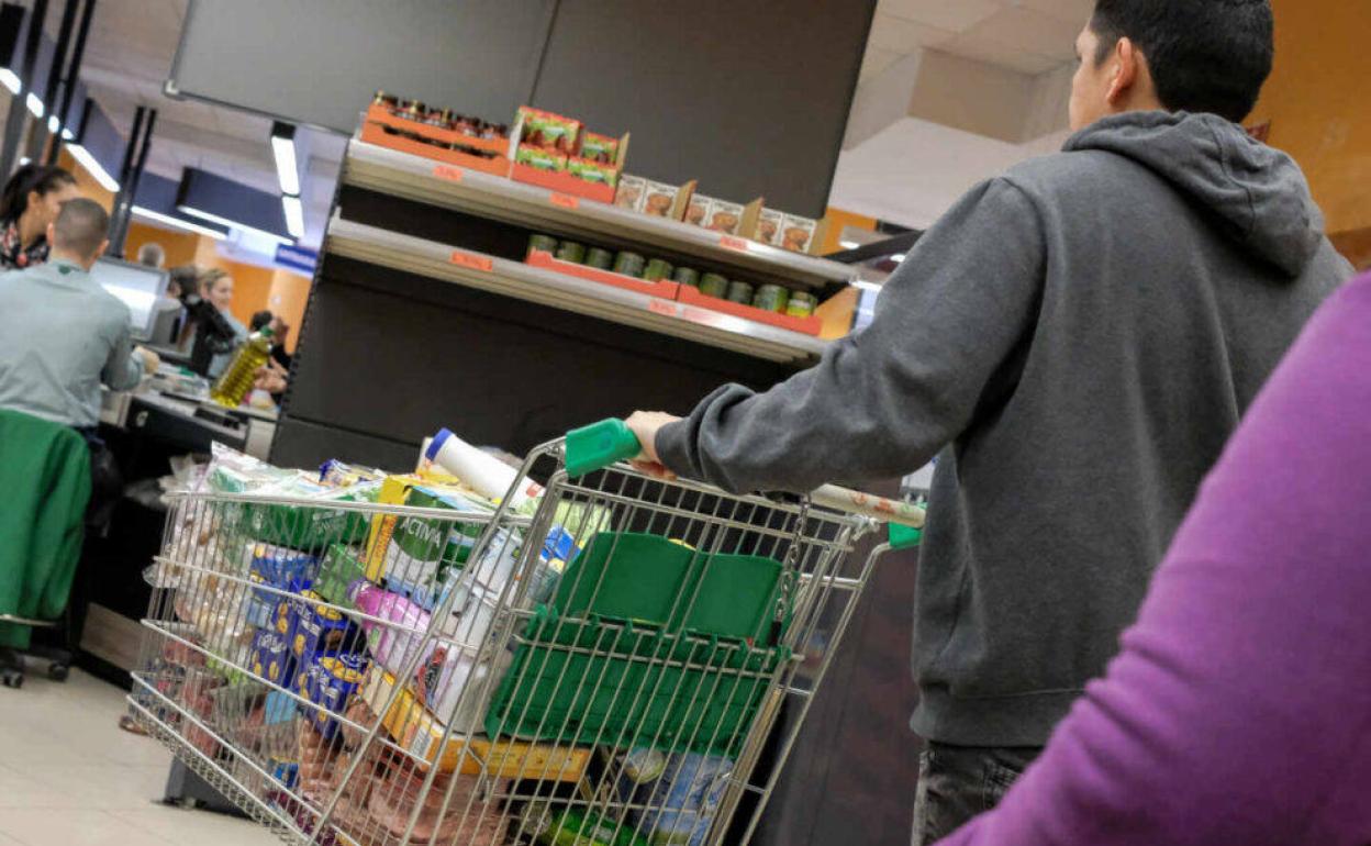 Clientes haciendo la compra en un supermercado. 