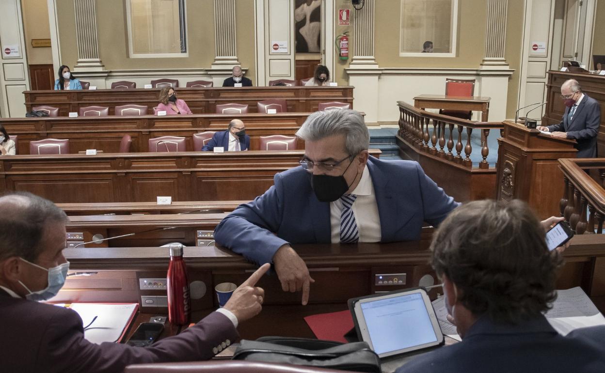 El vicepresidente y consejero de Hacienda del Gobierno de Canarias, Román Rodríguez (c), hablando con diputados. 