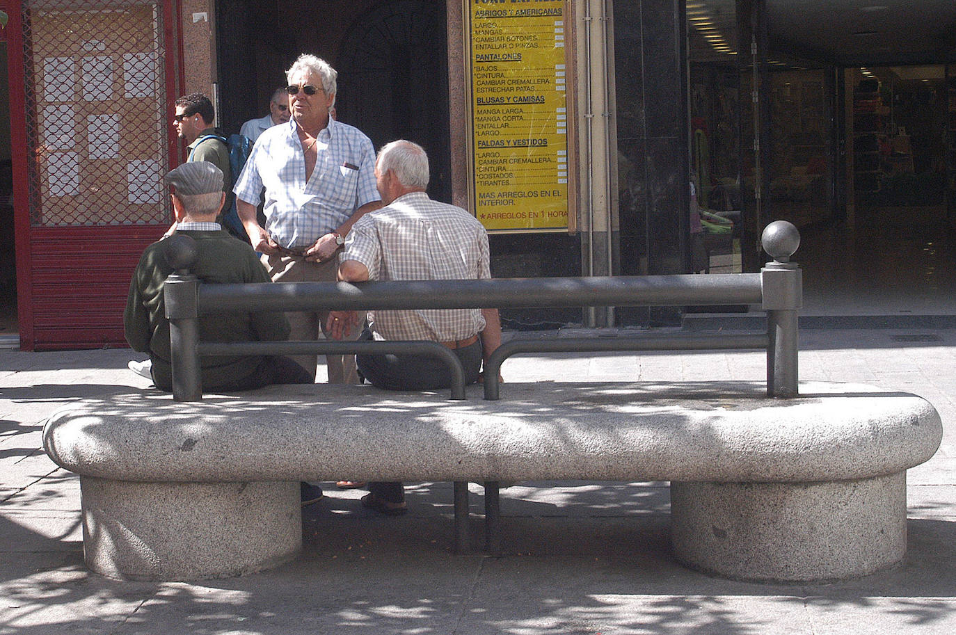 Unos jubilados conversan en un banco.