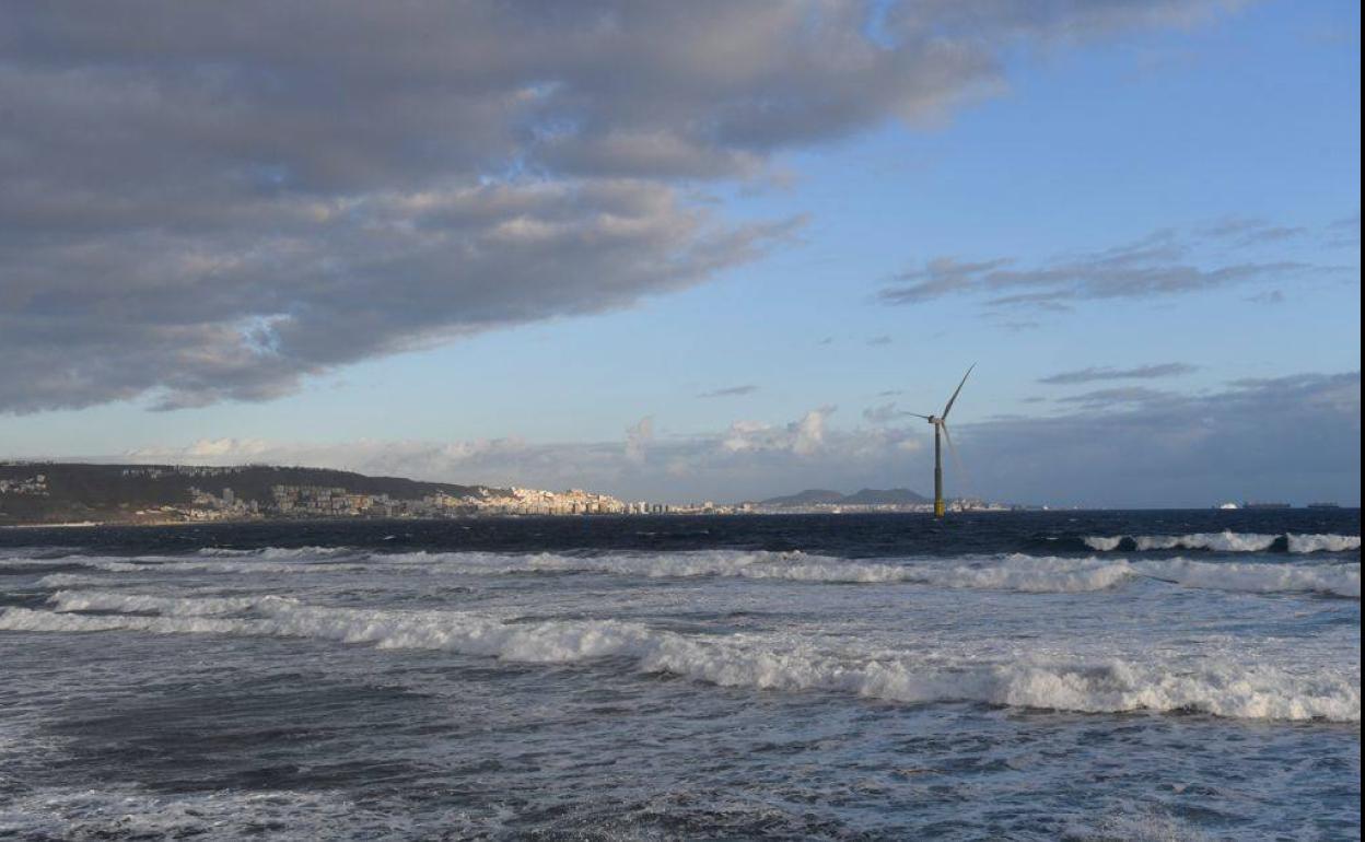 Imagen del molino eólico instalado en el puerto de Arinaga, con la localidad al fondo. 
