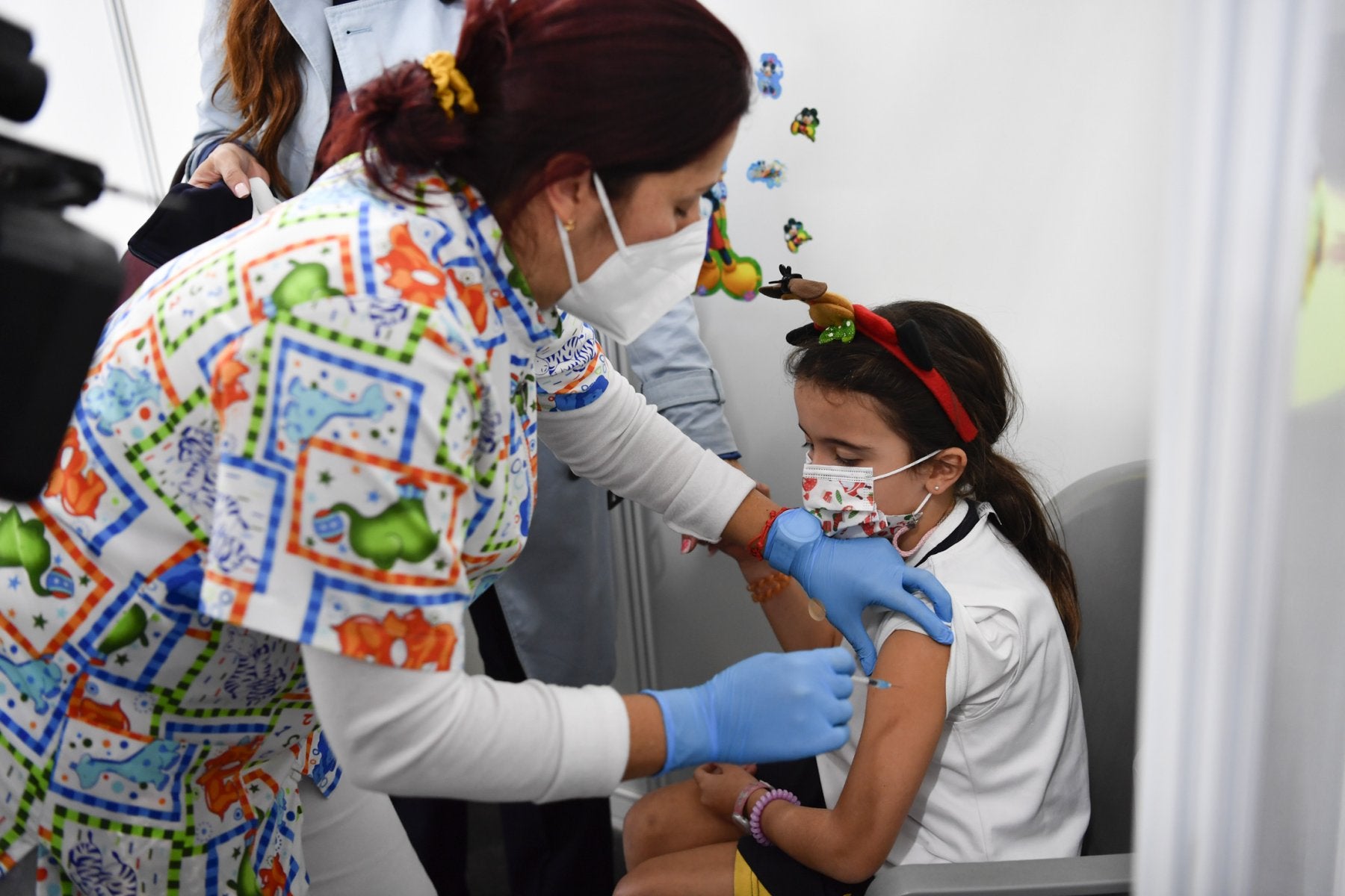 Una sanitaria pone la primera dosis de la vacuna contra la covid a una niña este miércoles en Infecar. 