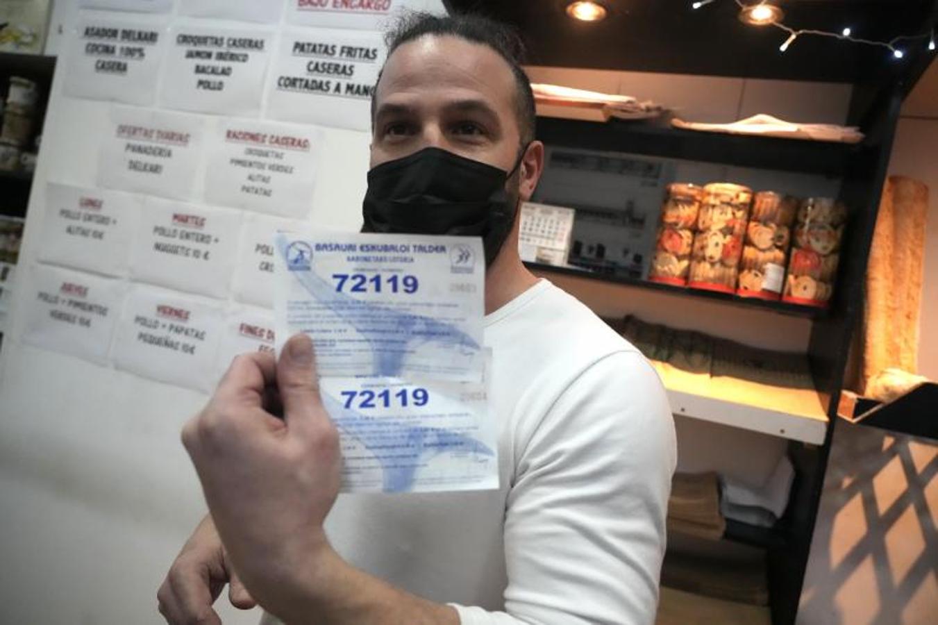 El empleado de una panadería cercana a la administración de lotería muestra sus dos papeletas. 