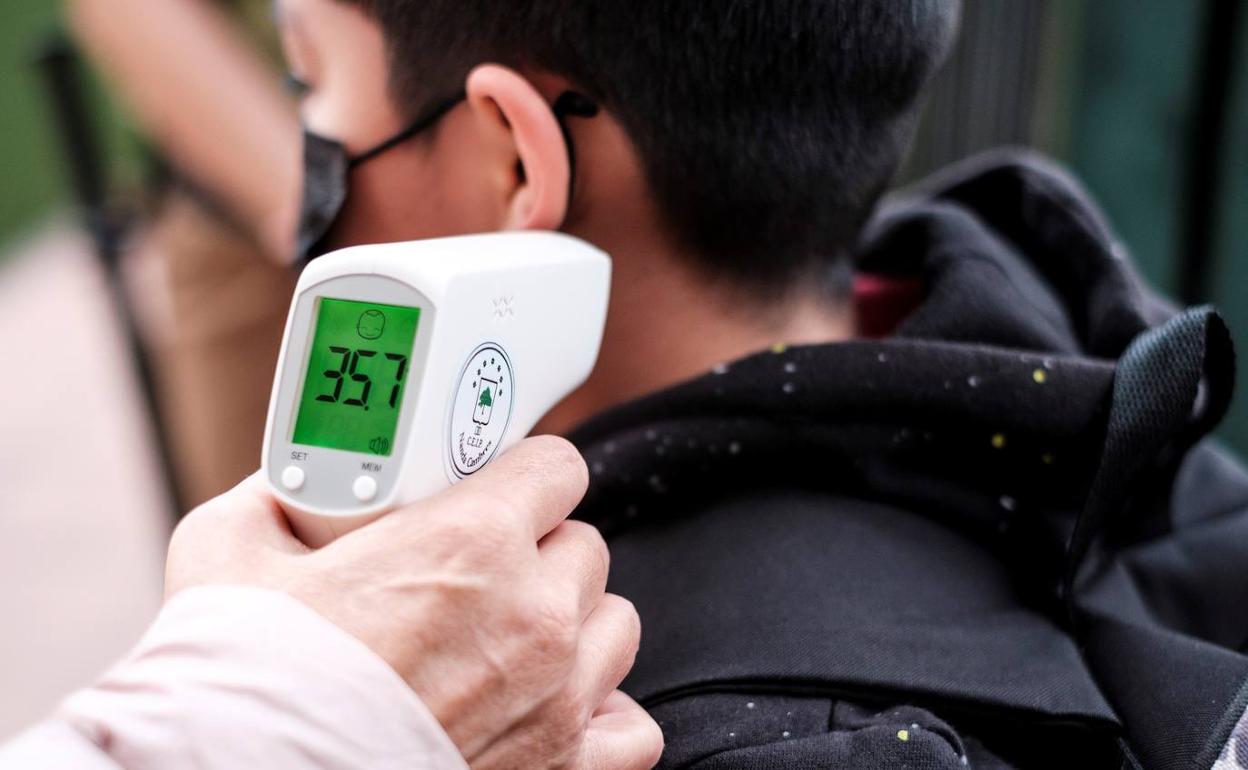Toma de temperatura a un menor antes de acceder a clase en Canarias. 