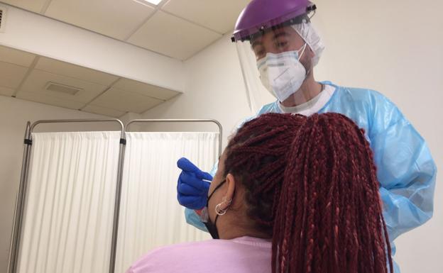 Un sanitario del Servicio Canario de Salud realiza un test a una sospechosa de estar infectada. 