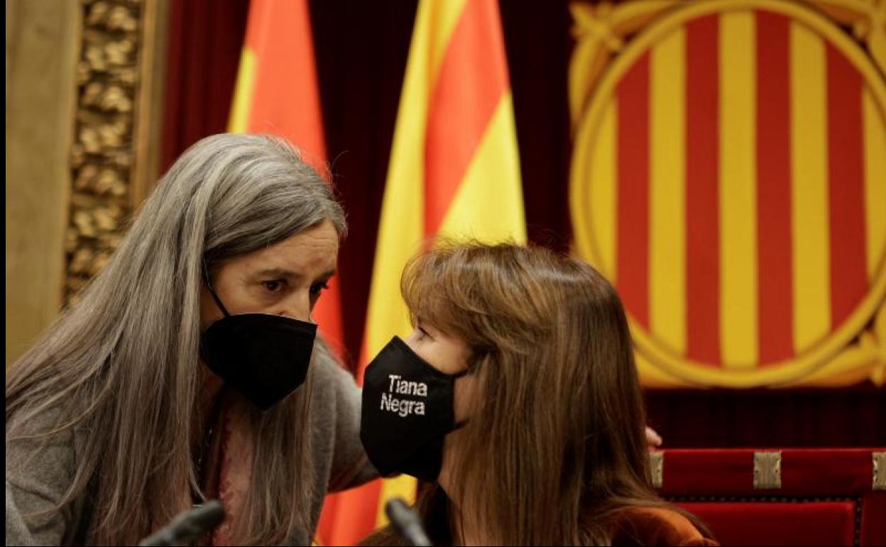 La presidenta de la cámara catalana, Laura Borràs (d), conversa con la secretaria general de la cámara, Esther Andreu.