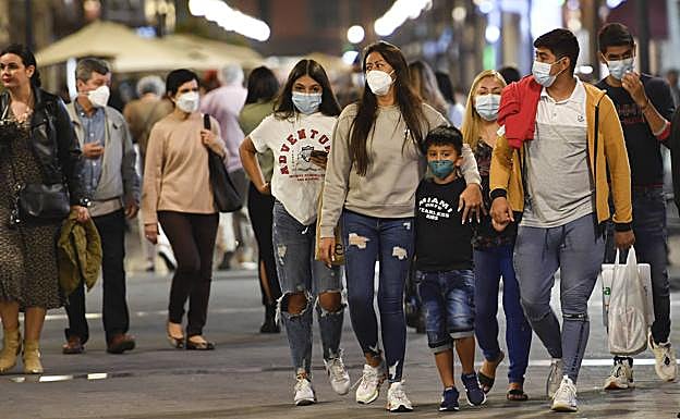 Personas con mascarillas mientras caminaban en la noche del viernes por la calle Mayor de Triana. 