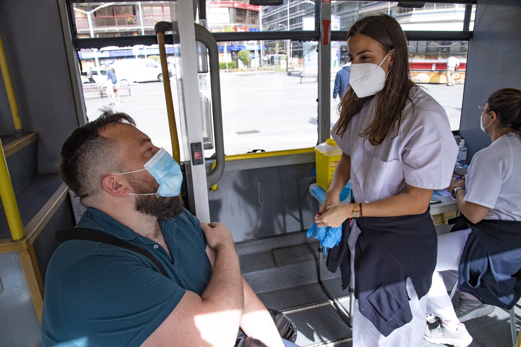 Una sanitaria conversa con un hombre tras vacunarle contra la oovid en la vacuguagua. 