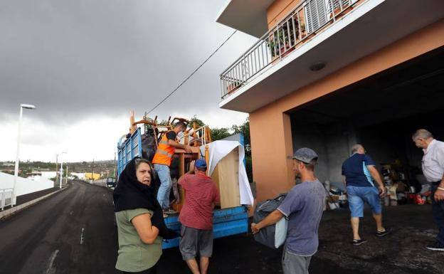 Una familia de desalojados en el barrio de La Laguna recoge sus enseres./ 