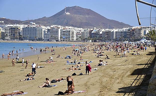 Los bañistas aprovechan las buenas temperaturas para acercarse a la playa de Las Canteras. / 