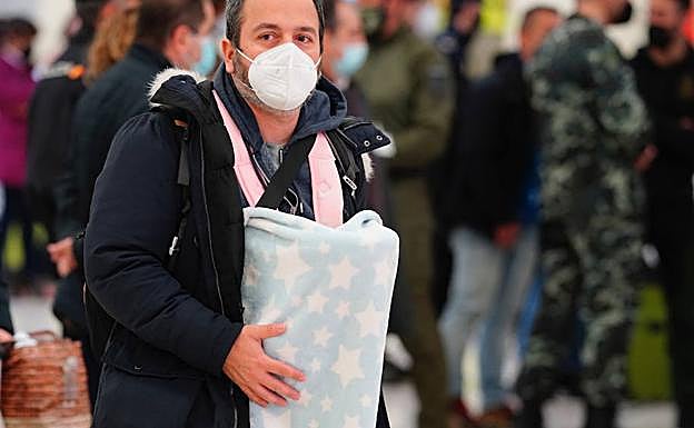 Imagen de uno de los españoles portando a su bebé. 