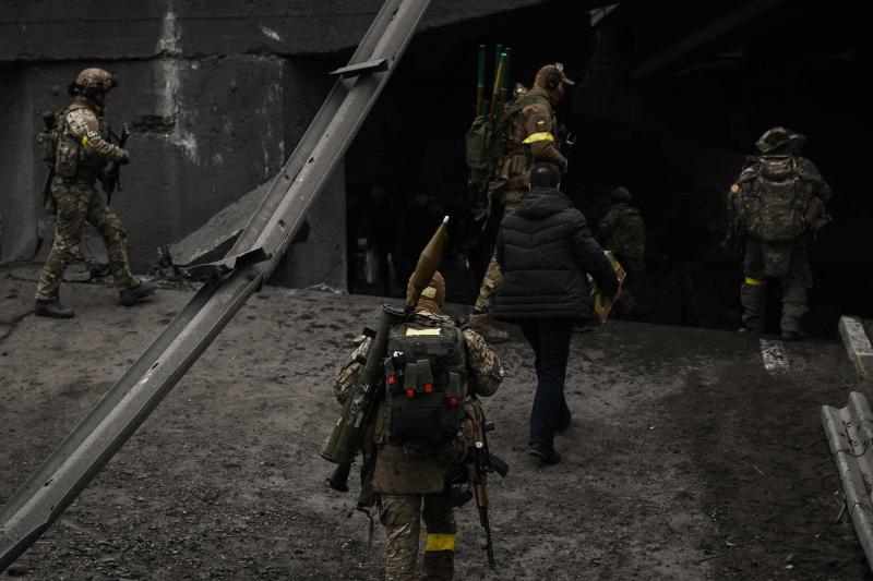 Militares ucranianos caminan a través de un puente destruido en Irpin.