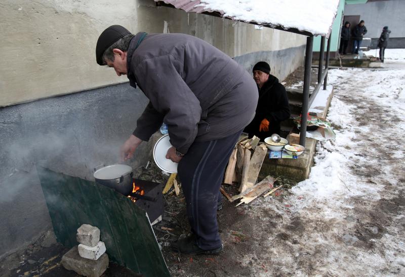 Dos ucranianos preparan la comida en la ciudad de Popasna, en la región de Lugansk, que ya no tiene electricidad ni gas. 