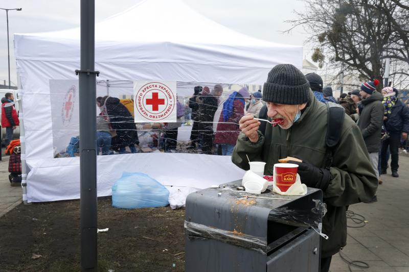 Un hombre comiendo después de llegar a la ciudad de Lviv, donde miles de refugiados que huyen de los bombardeos son atendidos por organizaciones humanitarias.