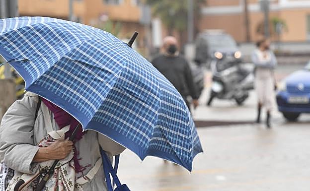 Imagen de archivo de una mujer sosteniendo un paraguas en la capital grancanaria. 