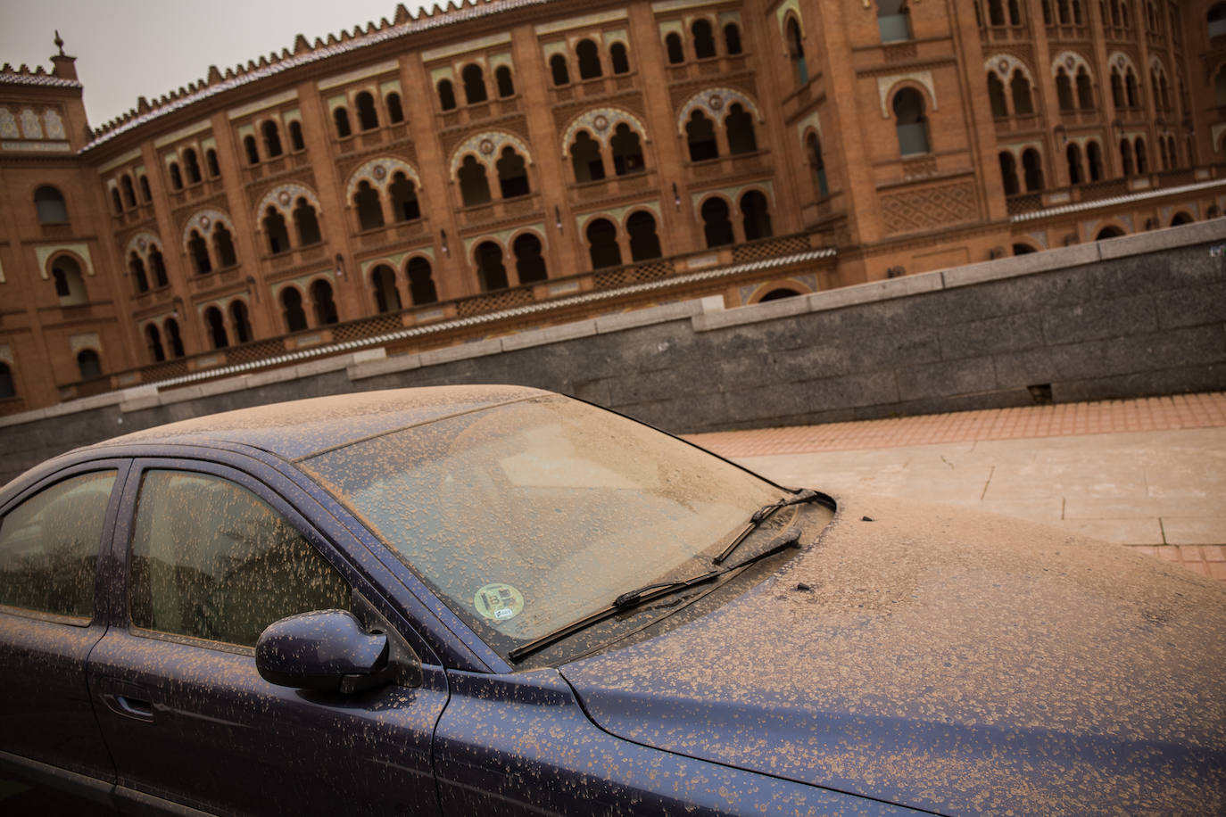 Un coche cubierto por tierra junto a la Plaza de Toros de Las Ventas, en Madrid. 