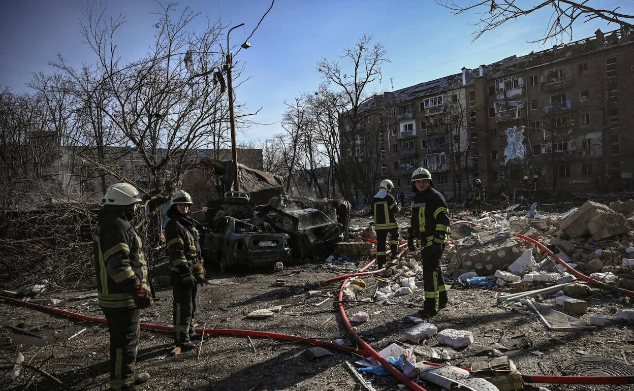 Los servicios de emergencias trabajan en un barrio de Kiev tras ser bombardeado. 