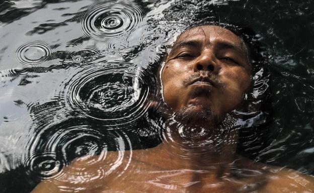 Un hombre contiene la respiración mientras nada en una fuente termal a las afueras de Kuala Lumpur, Malasia, el 22 de marzo de 2022, Día Mundial del Agua. 