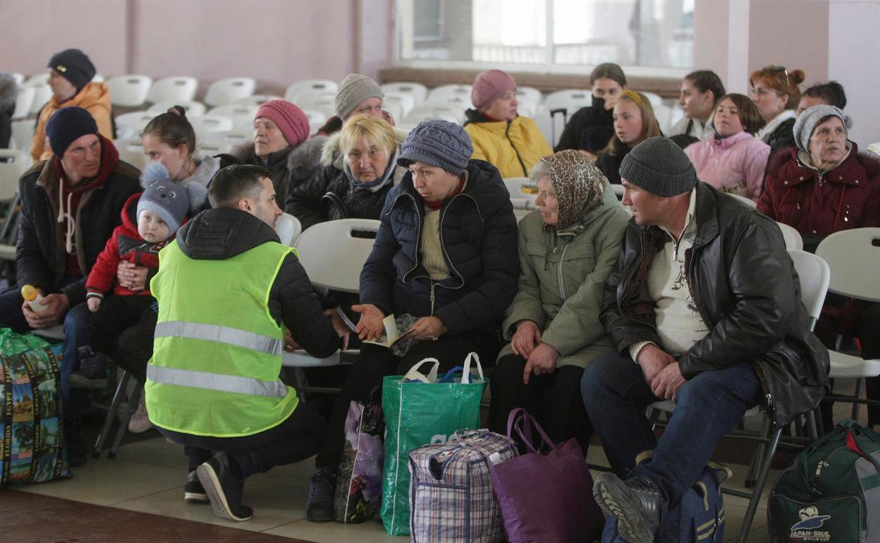 Un voluntario ayuda a un grupo de refugiados en la estación de Odesa. 